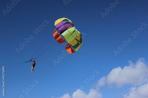 Colorful parachute flying on stormy sky.