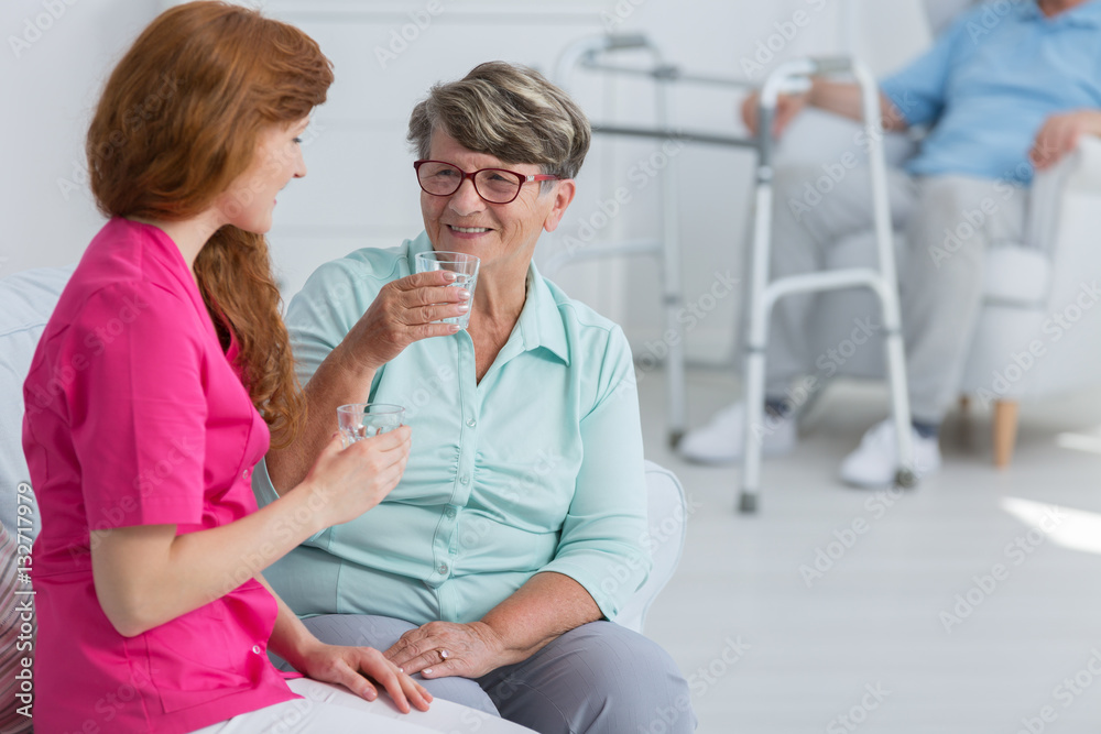 Obraz premium Nurse drinking water with senior woman