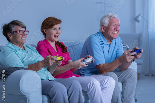 Elderly couple and caregiver playing