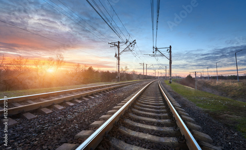 Railway station against beautiful sunny sky. Industrial landscape with railroad, blue sky and colorful clouds at sunset . Railway junction in the evening. Heavy industry. Cargo shipping. Travel