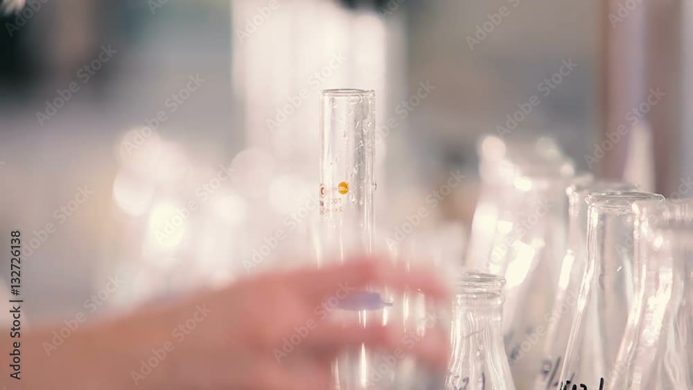A woman fills a volumetric flask with water.