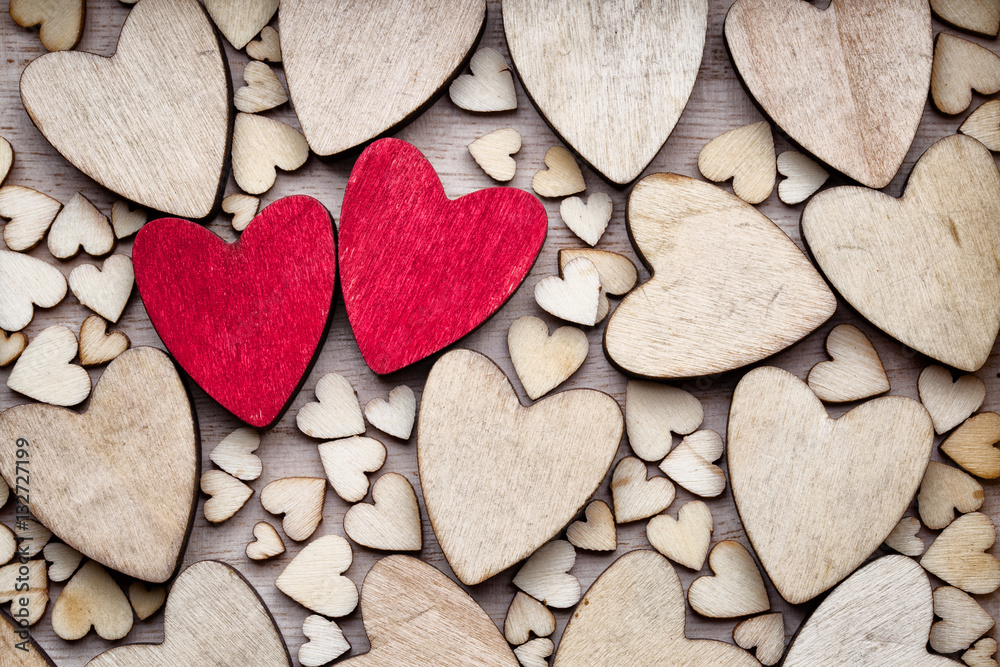 Wooden hearts, one red heart on the heart background. Stock Photo