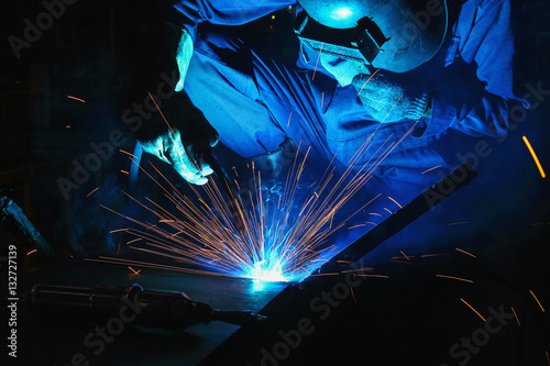 Welder of Metal Welding with sparks and smoke in manufacturing
