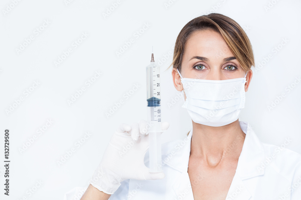 portrait d'une femme médecin avec un masque et une grosse seringue portrait d'une femme médecin avec un masque et une grosse seringue