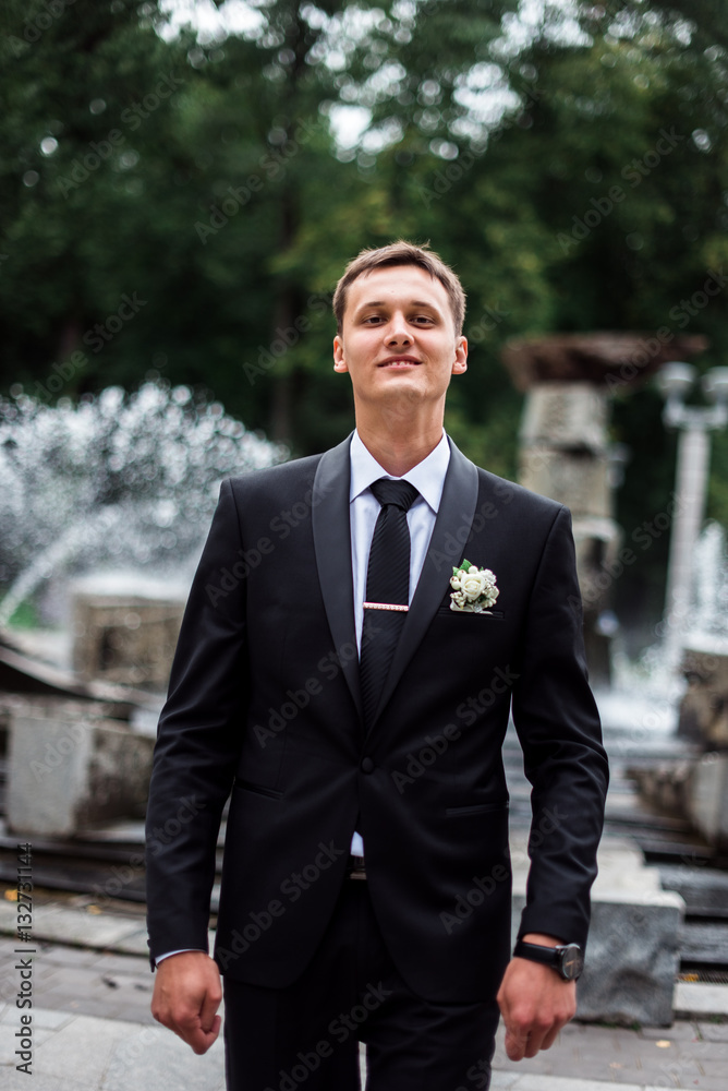 groom with the fountain on the background groom with the fountain on the background
