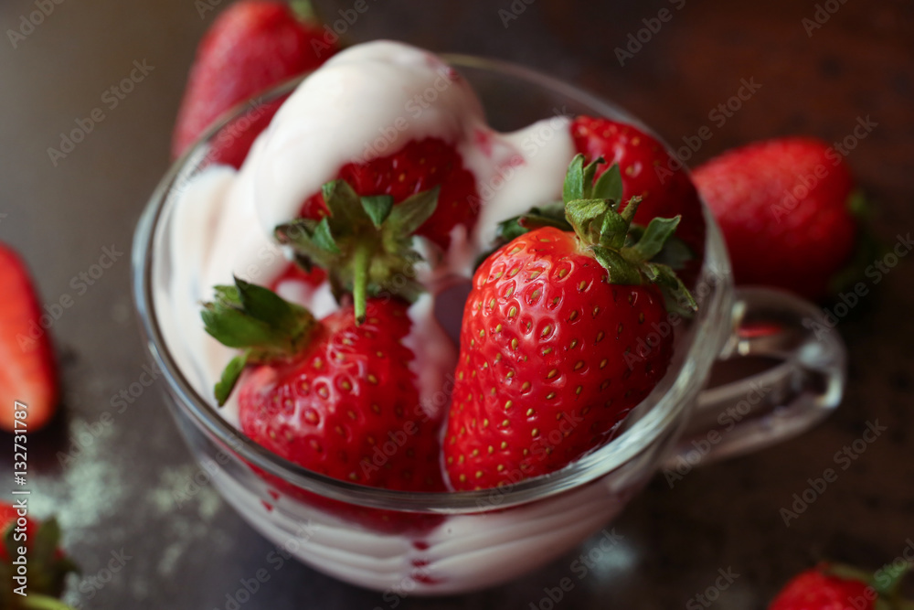 Tasty cream and strawberries dessert in the glass bowl on the dark background in the restaurant Tasty cream and strawberries dessert in the glass bowl on the dark background in the restaurant