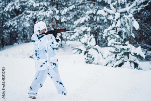 portrait of a beautiful girl in white camouflage hunter with a g