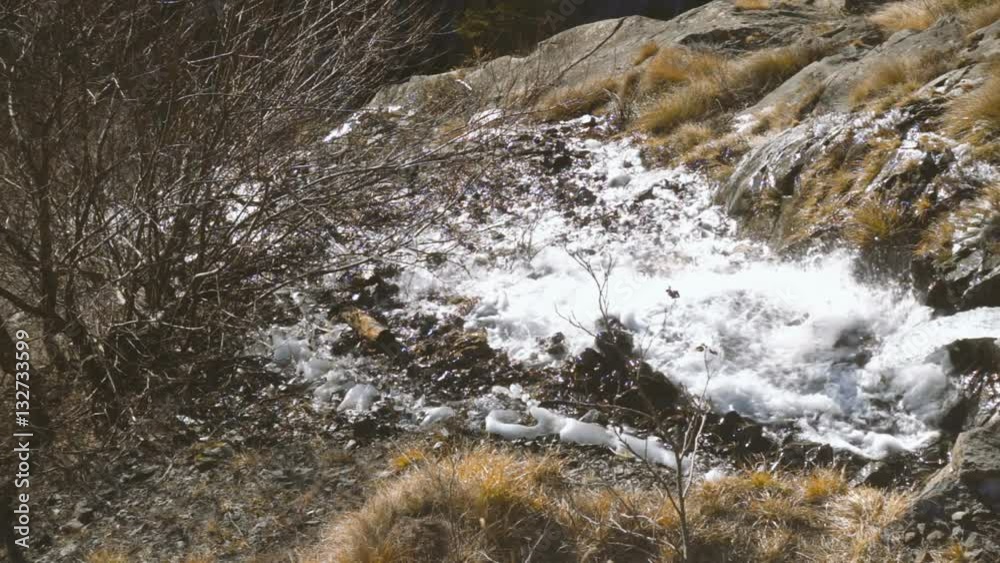 Flow of rushing water on the mountain side in slow motion