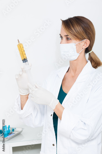 portrait de femme en blouse blanche avec un masque chirurgical et un  bistouri Stock Photo