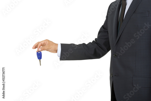 Man in a suit holding a car key