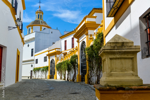 white with yellow decorated houses in the old streets houses of Seville, Spain