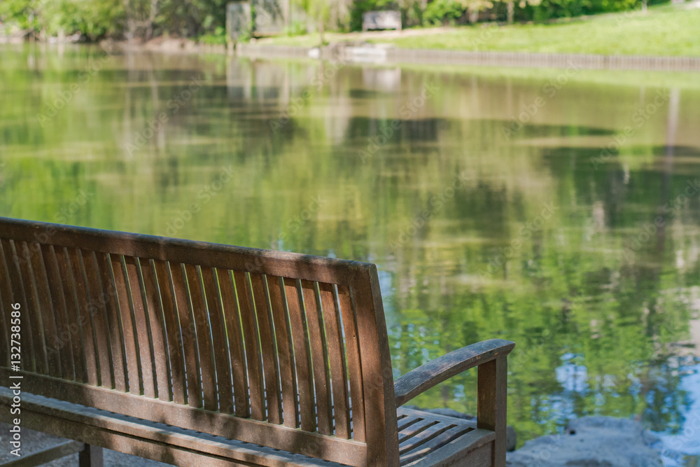 Peaceful spot to sit and relax.  Park bench with lake. 