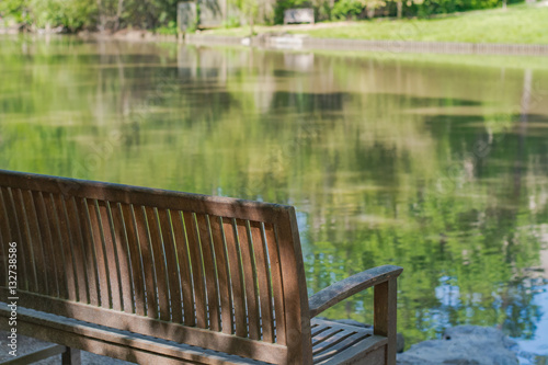 Obraz na płótnie Peaceful spot to sit and relax. Park bench with lake. w salonie