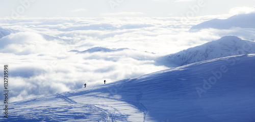 Two skiers walking up a mountain