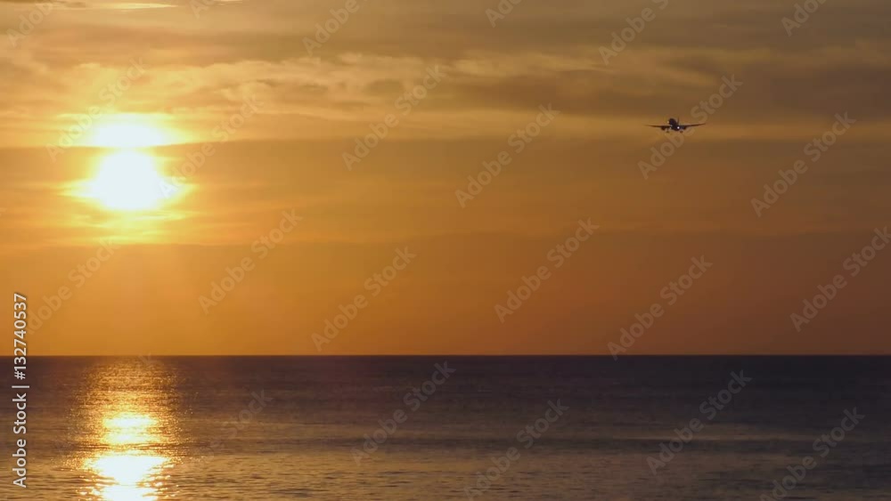 Airplane flying through picturesque sunset