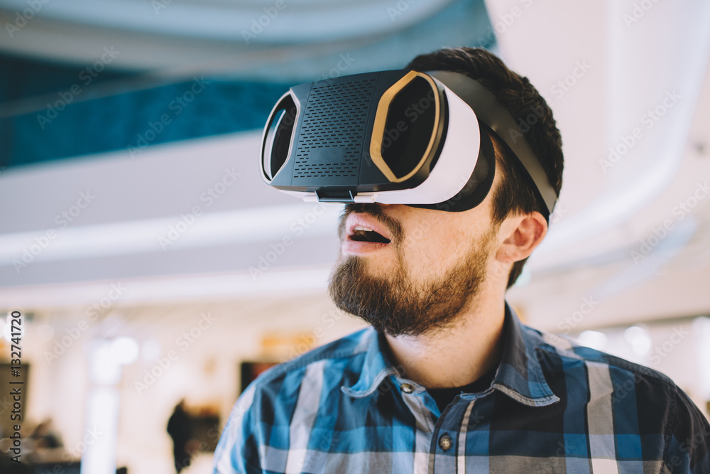 Young man trying vr goggles in the shopping centre Young man trying vr goggles in the shopping centre