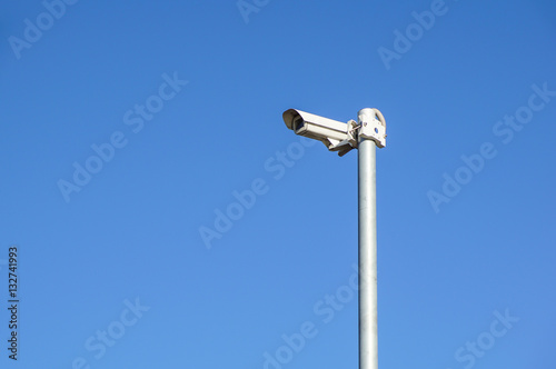 Security camera for surveillance on blue sky background