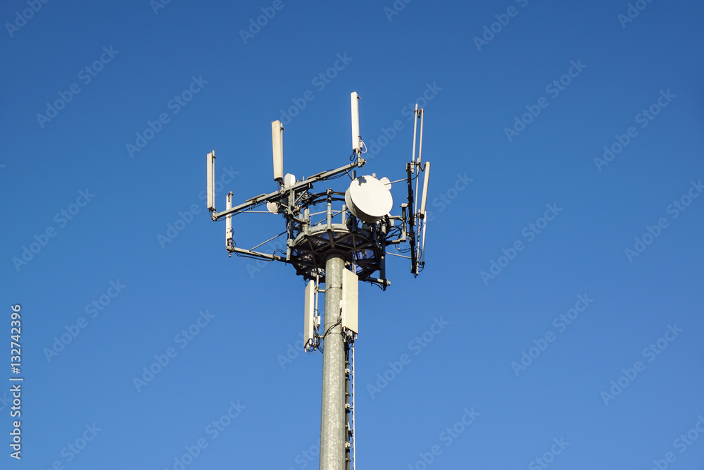Modern Cellular Tower - Communication antenna on Blue Sky. Vertical Photography.