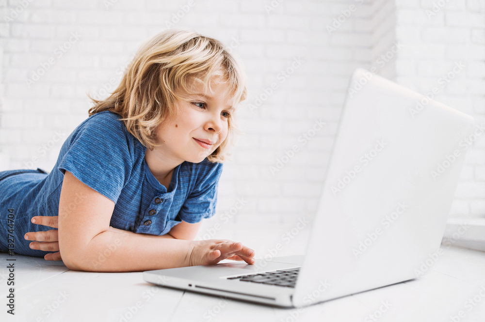 Cute little boy using laptop at home Cute little boy using laptop at home