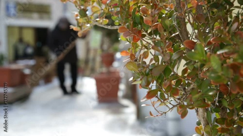 Spazzino sta pulendo la neve dai marciapiedi photo