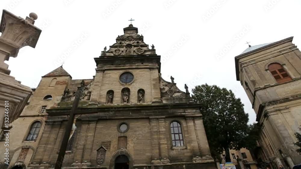 Old chruch with dark grey walls and ancient pillars stand on city-square Old chruch with dark grey walls and ancient pillars stand on city-square