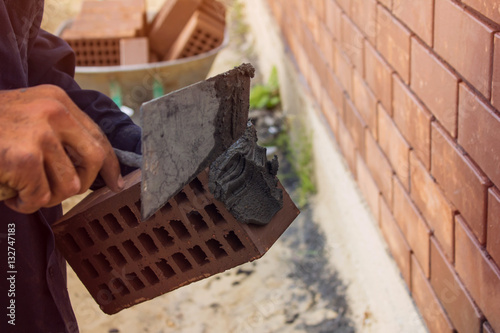 Bricklayer lays bricks under unravel. construction work