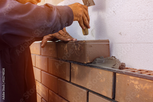Bricklayer lays brick gently tapping with a trowel. construction work