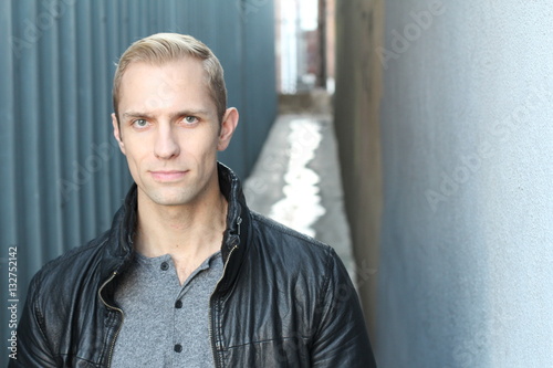 Close up portrait of blond haired handsome male dressed in a black leather jacket