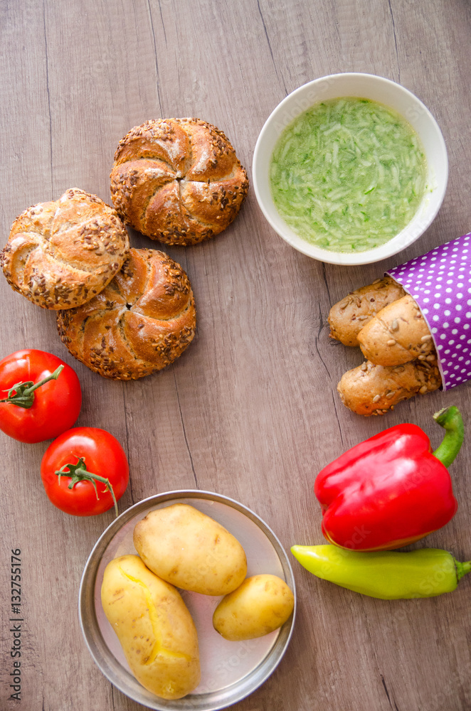 Pepper, potato, kaiser bun and baguette on wood table. Vegetarian bio food concept. Pepper, potato, kaiser bun and baguette on wood table. Vegetarian bio food concept.