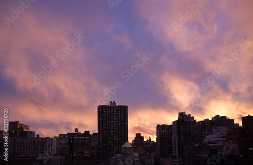 Dark silhouette tops of Manhattan cityscape, bright purple-orang © anaglic