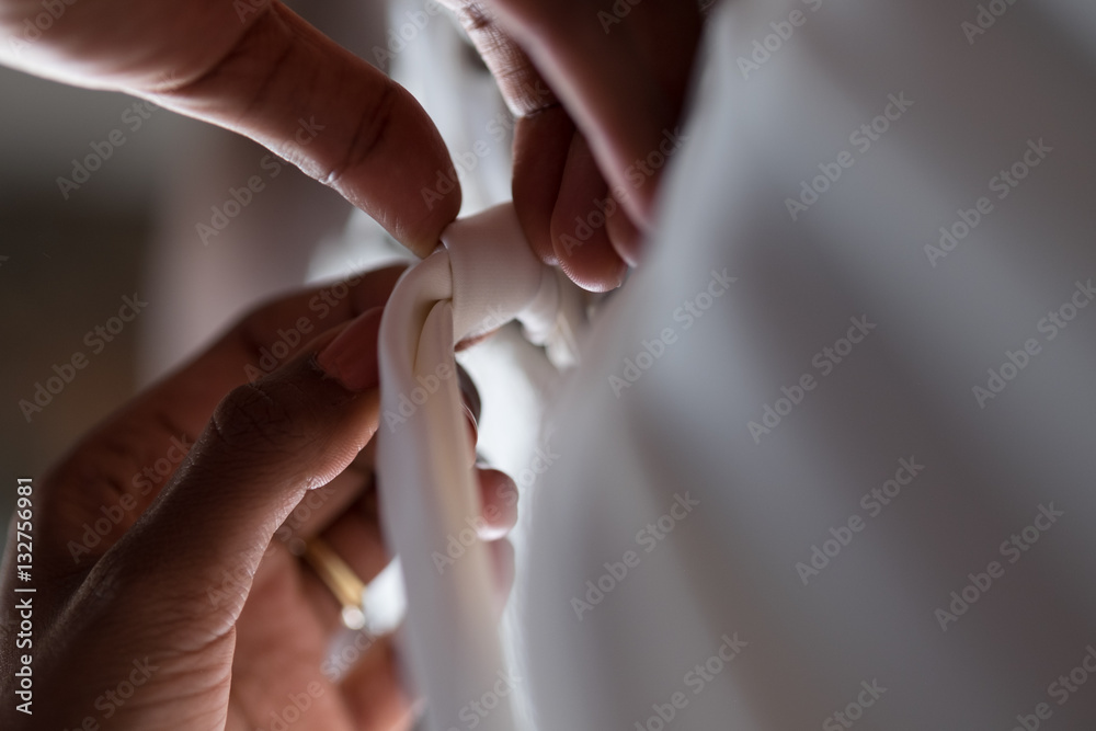 bride putting on wedding dress close up