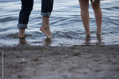 Obraz na płótnie lovers playing in the water with their feet w salonie