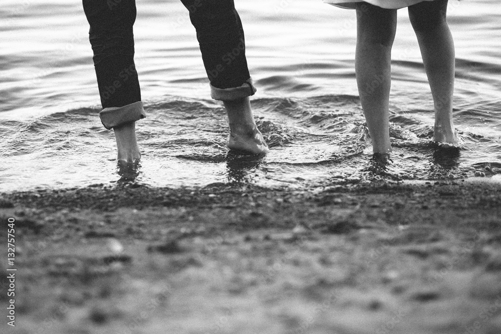 lovers playing in the water with their feet
