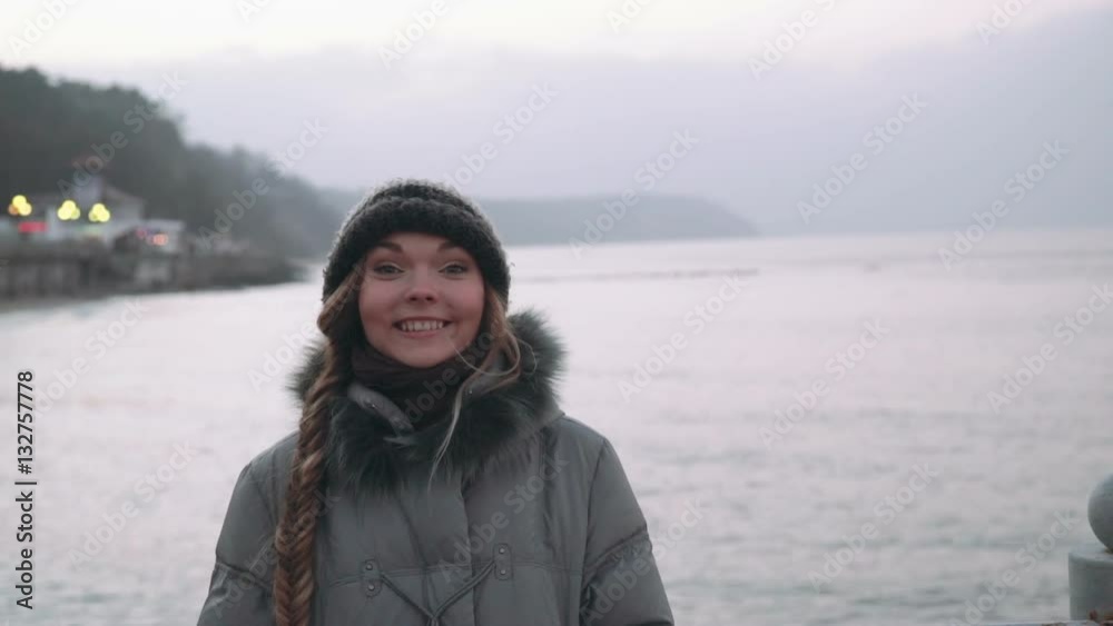woman on the pier watching at the camera on sea woman on the pier watching at the camera on sea