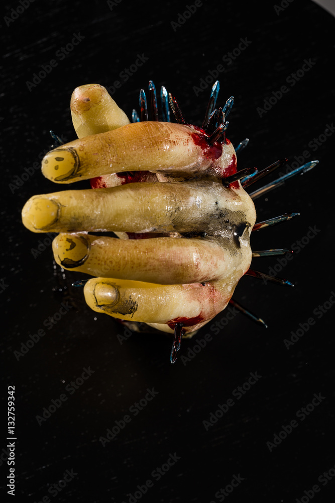 wax hand sculpture with nails and blood