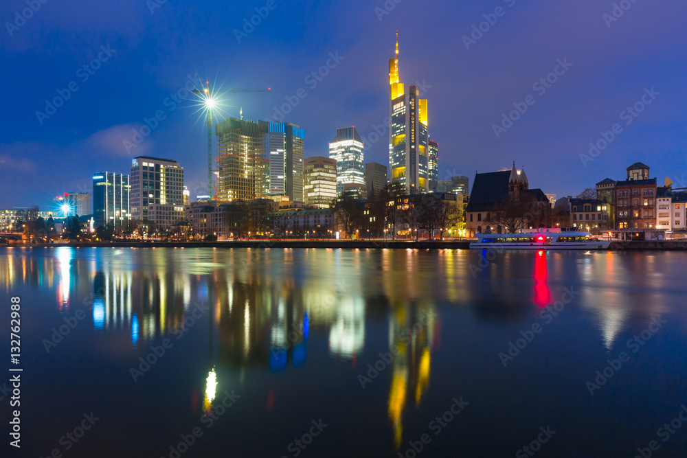 Picturesque view of business district with skyscrapers and mirror reflections in the river during morning blue hour, Frankfurt am Main, Germany