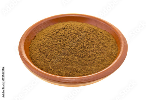  Carob powder in a bowl isolated on a white background.