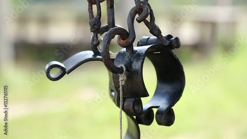 Old black iron shackles. Ancient hammered fetters. Iron forged gyves