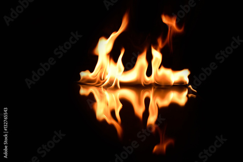   flames on a black background with mirror reflection © Ivan