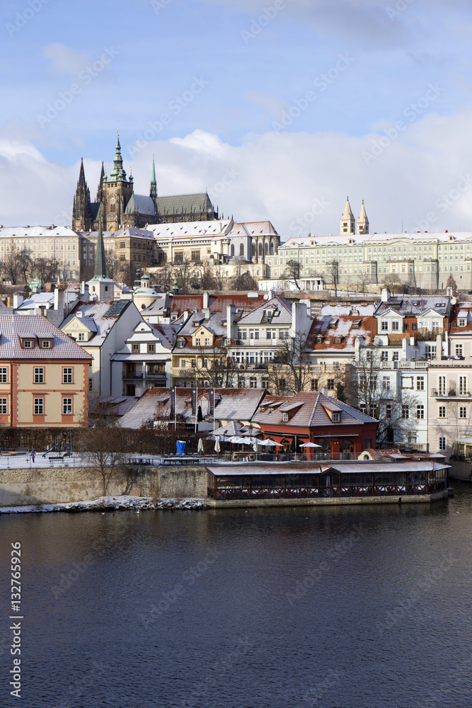 Fototapeta premium Snowy freeze Prague Lesser Town with gothic Castle above River Vltava, Czech republic