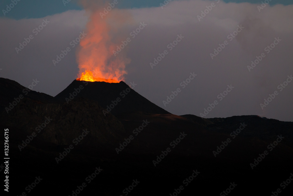 Ile de la reunion island Piton de la fournaise volcano eruption with lava flow and steam at night
