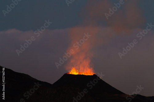 Ile de la reunion island Piton de la fournaise volcano eruption with lava flow and steam at night