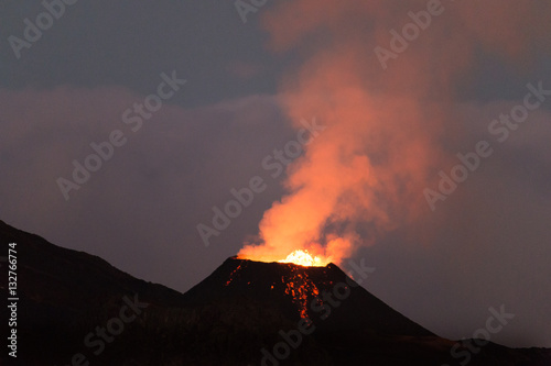 Ile de la reunion island Piton de la fournaise volcano eruption with lava flow and steam at night
