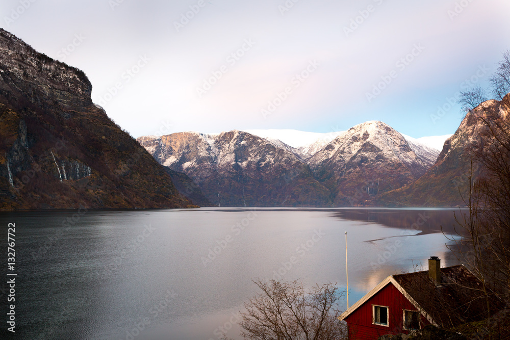 Norway geiranger Fjord red little cottage house in winter at sunset