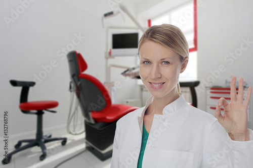 Smiling Female doctor dentist showing Ok or Alright Sign.