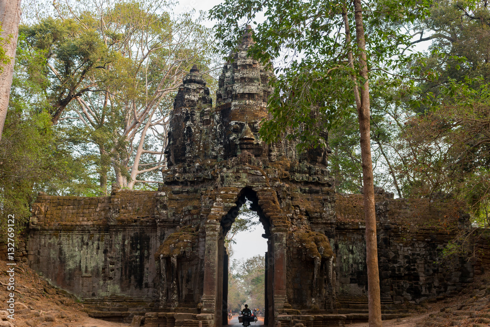Cambodia Angkor Wat ancient stone arch with tuk tuk driver