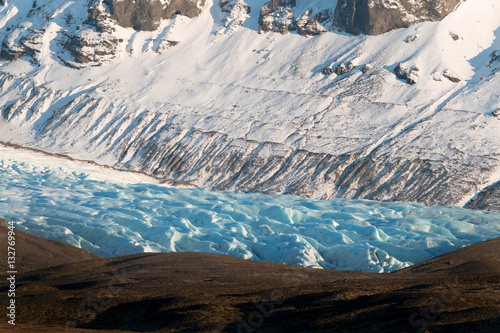 Iceland myrdalsjokull glacier tongue with blue ice and snow mountain background in winter photo