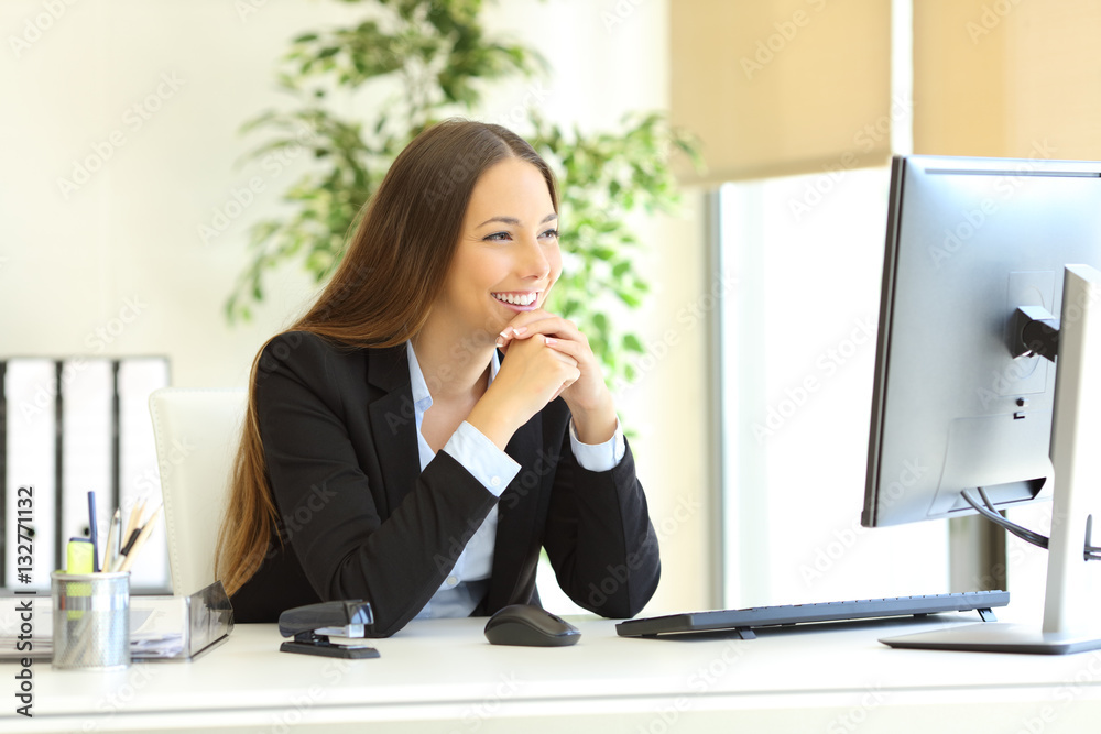 Businesswoman looking attentive to pc monitor Businesswoman looking attentive to pc monitor