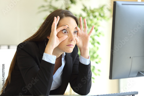 Sleepy businesswoman trying to keep eyes opened