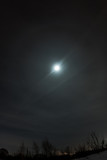 Halo 22° around the full moon in the winter sky with clouds
